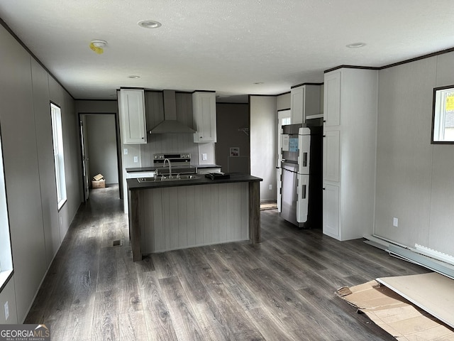 kitchen featuring wall chimney exhaust hood, sink, stainless steel refrigerator, dark hardwood / wood-style flooring, and a wealth of natural light