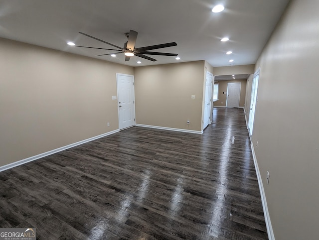 empty room with ceiling fan and dark hardwood / wood-style flooring