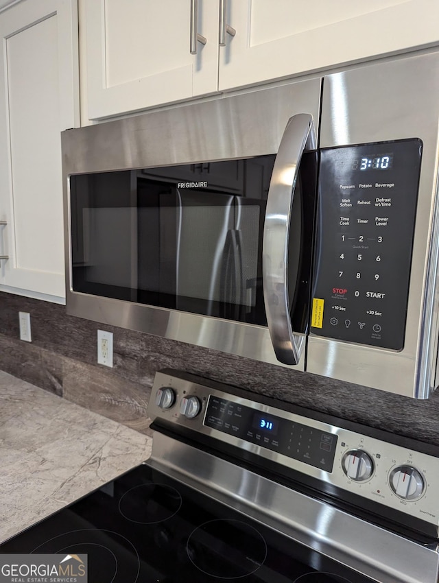 kitchen featuring white cabinetry, appliances with stainless steel finishes, and backsplash