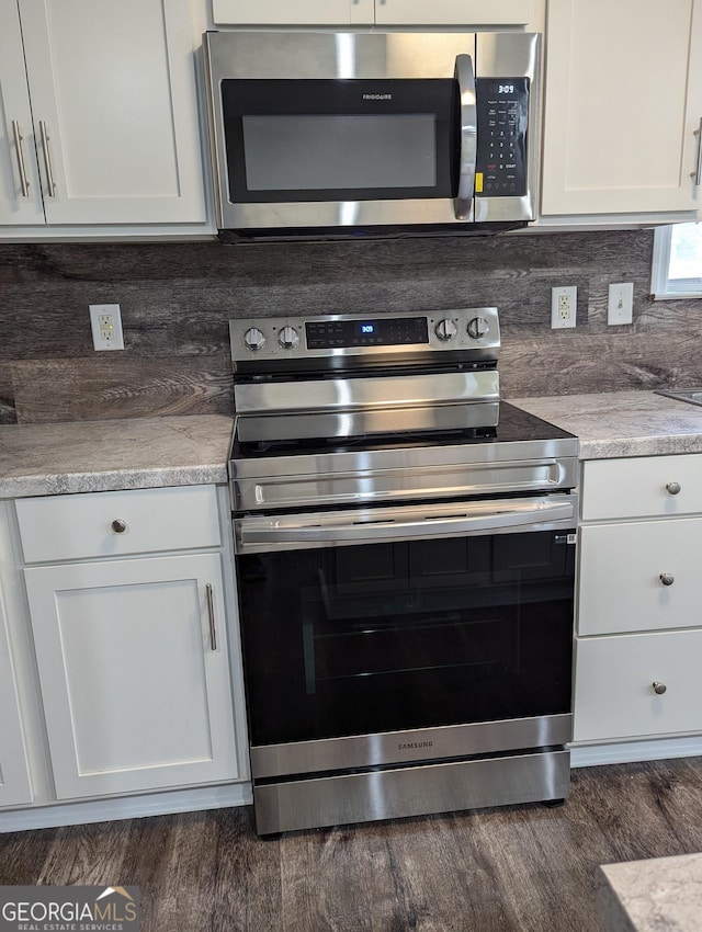 kitchen with stainless steel appliances, light stone countertops, decorative backsplash, and white cabinets