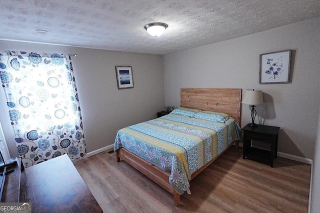 bedroom featuring hardwood / wood-style floors and a textured ceiling