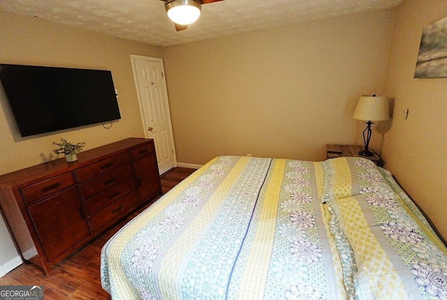 bedroom featuring dark hardwood / wood-style floors, a textured ceiling, and ceiling fan