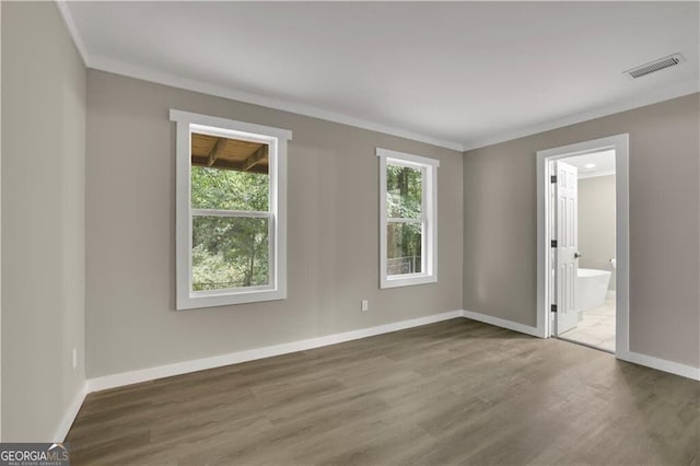 spare room featuring dark wood-type flooring and crown molding