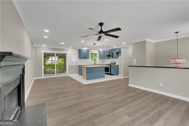 unfurnished living room featuring crown molding, ceiling fan, and light wood-type flooring