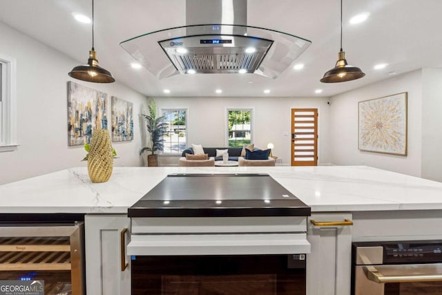 kitchen with wine cooler, island exhaust hood, decorative light fixtures, and light stone counters