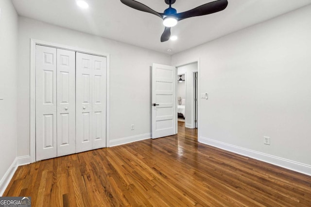 unfurnished bedroom featuring dark hardwood / wood-style floors, ceiling fan, and a closet