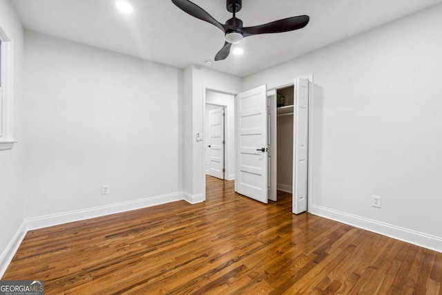 unfurnished bedroom featuring dark hardwood / wood-style flooring, ceiling fan, and a closet