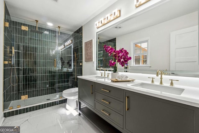 bathroom with vanity, a shower with door, and toilet