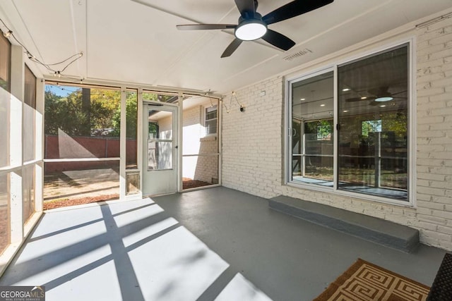 unfurnished sunroom with ceiling fan