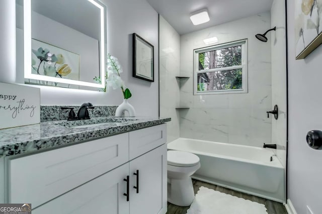 full bathroom featuring vanity, hardwood / wood-style floors, toilet, and tiled shower / bath