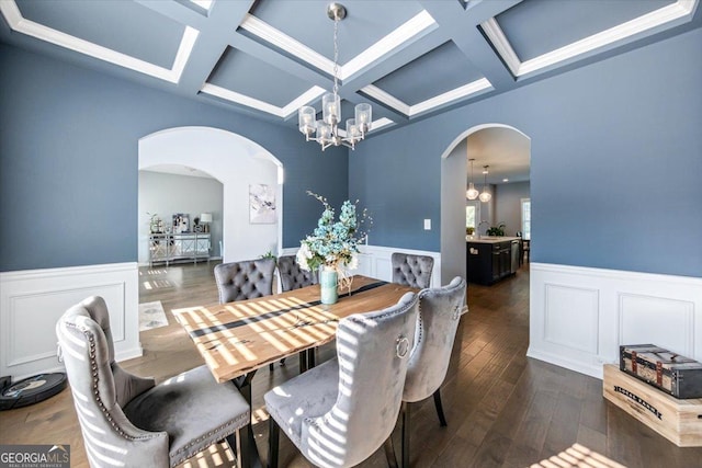 dining room with dark wood-type flooring, beamed ceiling, coffered ceiling, and a notable chandelier