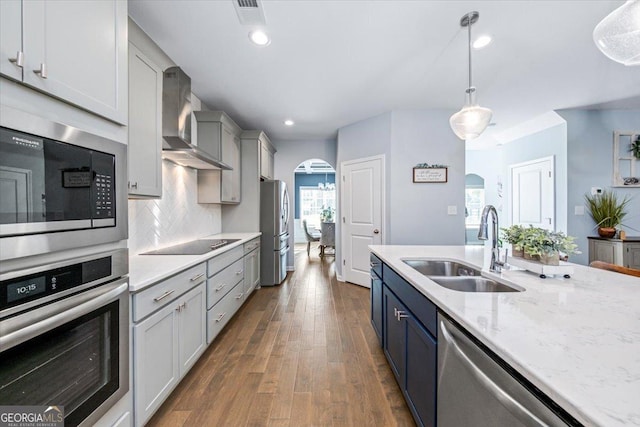 kitchen with dark hardwood / wood-style floors, tasteful backsplash, sink, hanging light fixtures, and stainless steel appliances