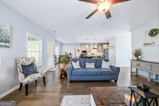 living room featuring dark wood-type flooring and ceiling fan