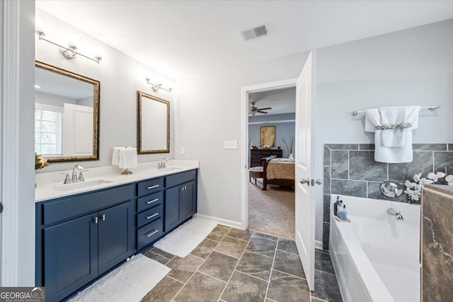 bathroom featuring vanity, a bath, and tile patterned flooring