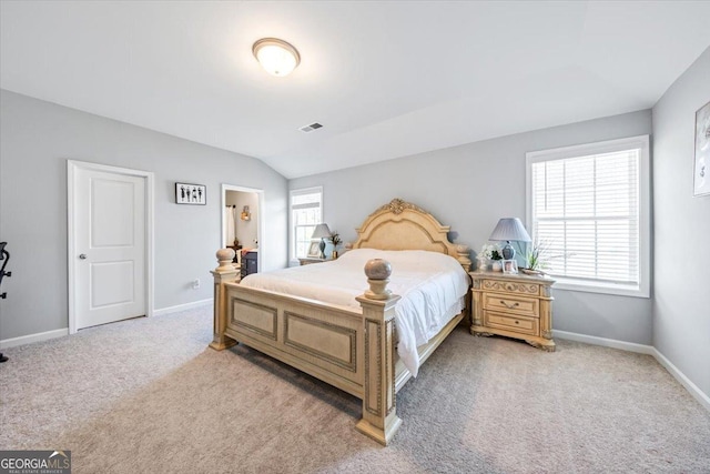 bedroom with multiple windows, vaulted ceiling, and light colored carpet