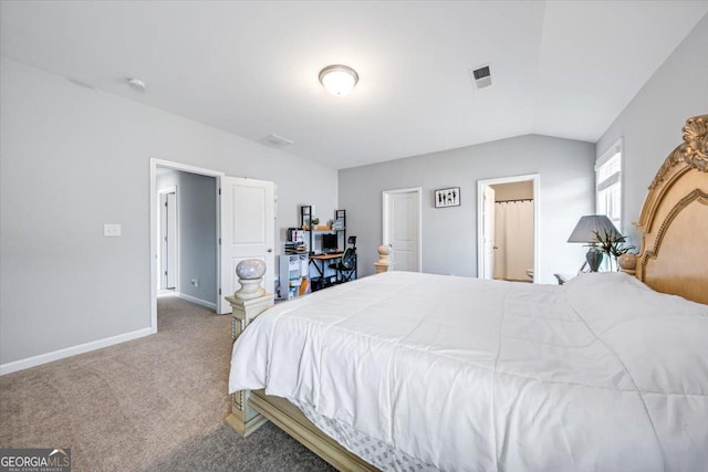 carpeted bedroom with ensuite bath and vaulted ceiling