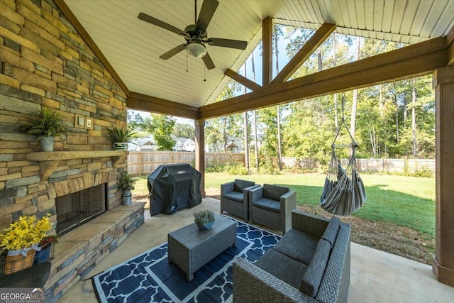 view of patio with ceiling fan, a grill, and an outdoor stone fireplace