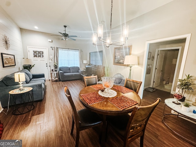 dining space with dark hardwood / wood-style flooring and ceiling fan with notable chandelier