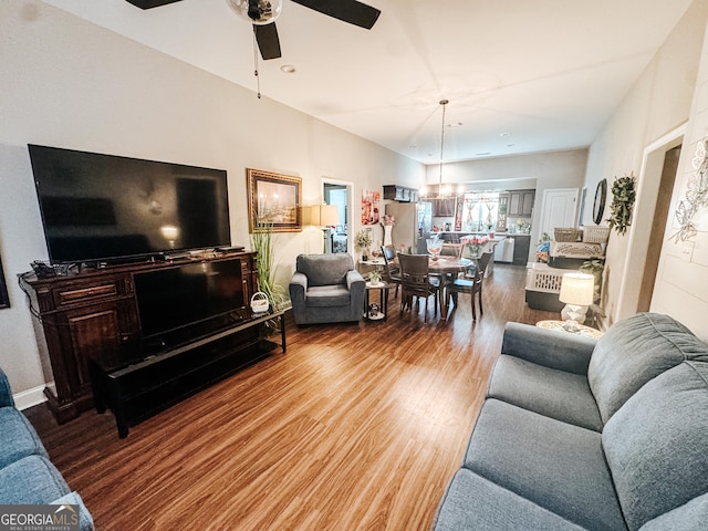 living room with hardwood / wood-style flooring and ceiling fan with notable chandelier