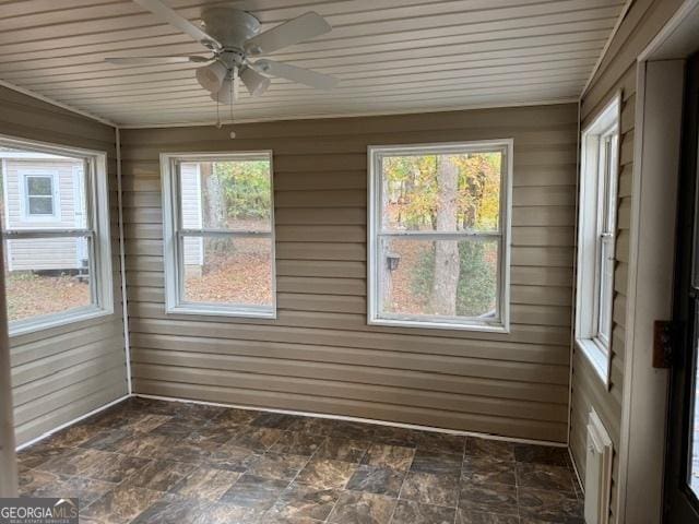 unfurnished sunroom with ceiling fan