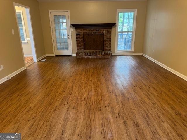 unfurnished living room with a fireplace and dark hardwood / wood-style floors