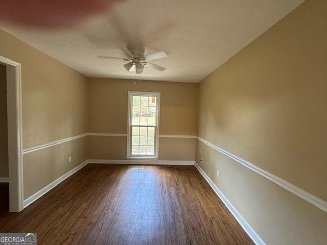 unfurnished room featuring dark wood-type flooring and ceiling fan