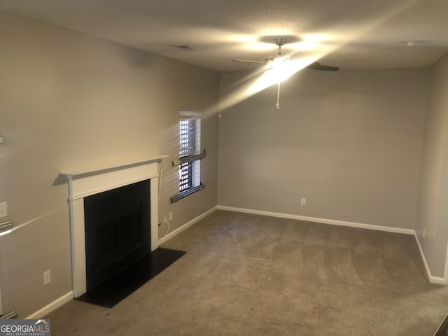 unfurnished living room with ceiling fan, carpet floors, and a textured ceiling