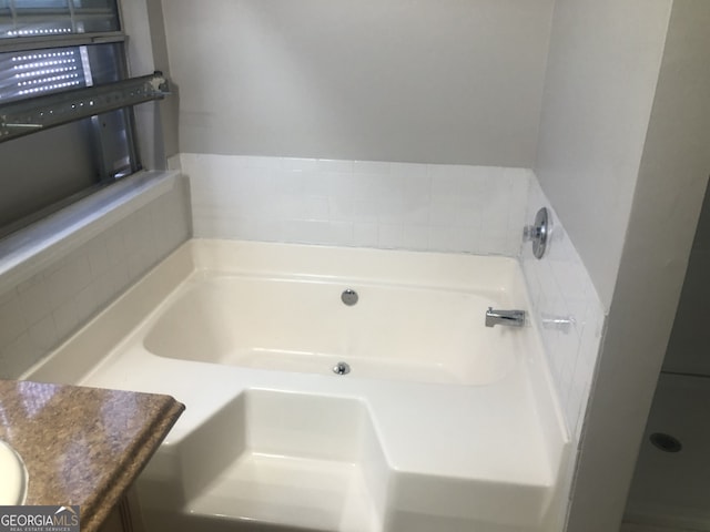 bathroom with vanity and a tub