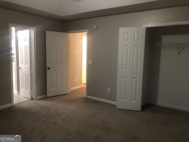 unfurnished bedroom with a closet and carpet flooring