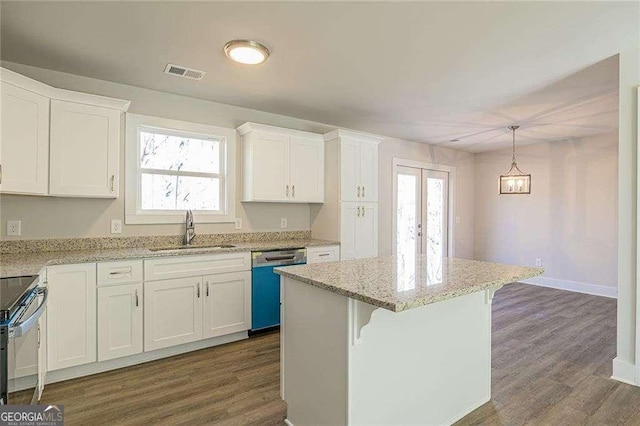 kitchen featuring sink, hanging light fixtures, stainless steel appliances, a center island, and white cabinets