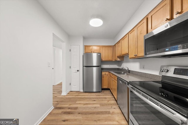 kitchen with stainless steel appliances, light hardwood / wood-style floors, and sink