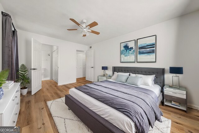 bedroom featuring connected bathroom, light hardwood / wood-style flooring, and ceiling fan