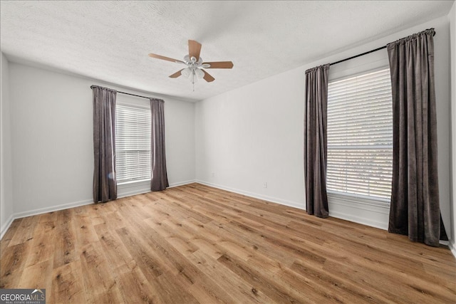 spare room featuring ceiling fan, a textured ceiling, and light wood-type flooring