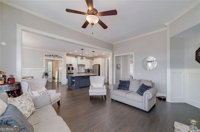 living room with crown molding, ceiling fan, sink, and dark wood-type flooring