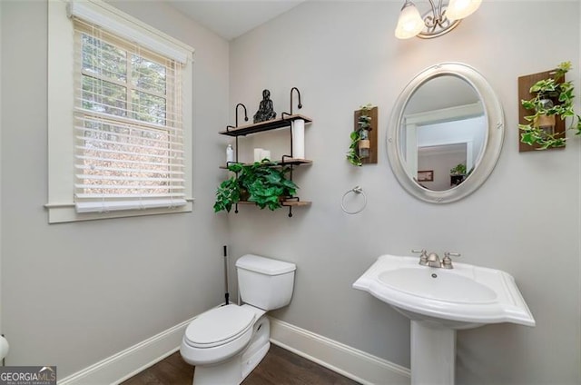 bathroom with sink, an inviting chandelier, and toilet