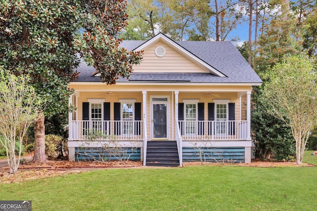 view of front facade with ceiling fan, covered porch, and a front lawn