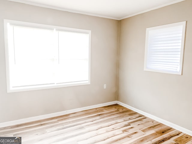 unfurnished room with crown molding and light hardwood / wood-style floors