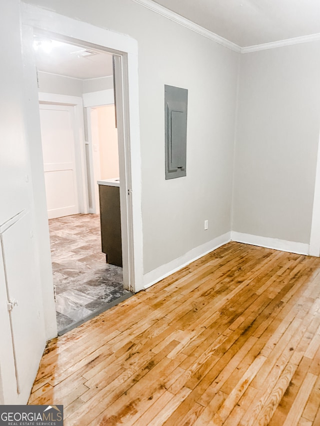 spare room with ornamental molding, electric panel, and wood-type flooring