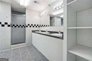 bathroom featuring tiled shower and sink