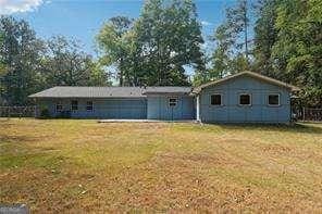 rear view of property featuring a yard