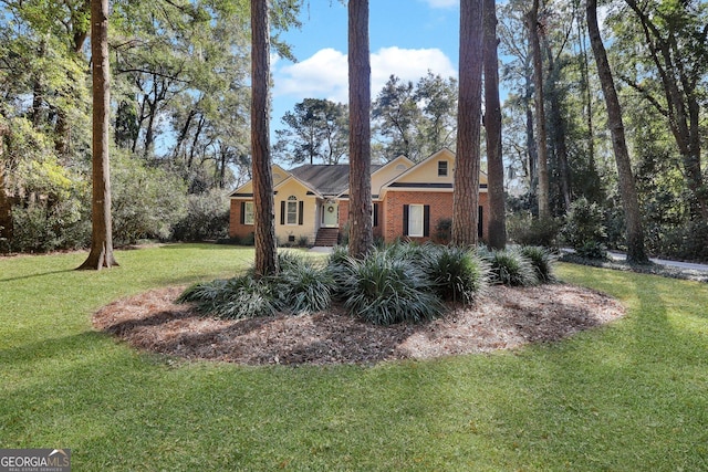 exterior space featuring brick siding and a front yard