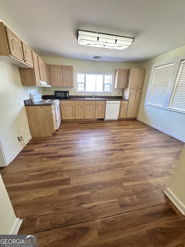 kitchen with light brown cabinetry, sink, white appliances, and dark wood-type flooring