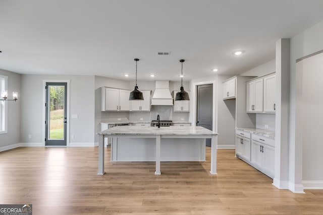 1611 Bethesda Church Rd, Carrollton, GA 30117 - kitchen with premium range hood, tasteful backsplash, light wood-style flooring, white cabinets, and recessed lighting