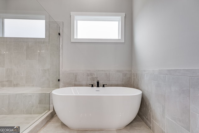 1611 Bethesda Church Rd, Carrollton, GA 30117 - full bathroom with tile walls, a soaking tub, a tile shower, and wainscoting