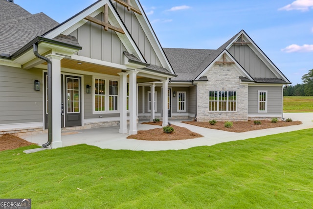1611 Bethesda Church Rd, Carrollton, GA 30117 - view of front of house with board and batten siding, a shingled roof, stone siding, and a front lawn