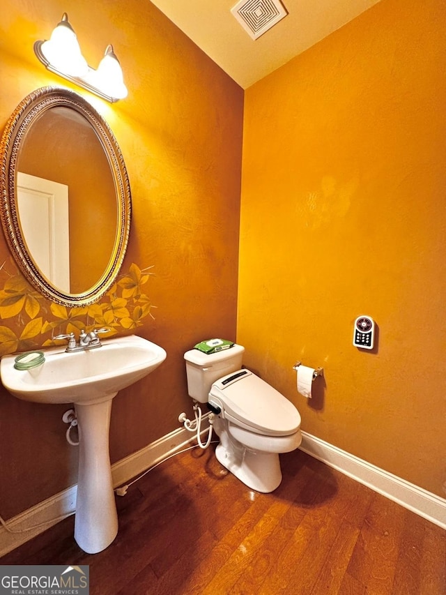 bathroom featuring hardwood / wood-style flooring and toilet