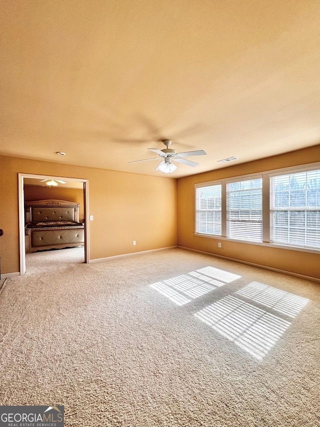 carpeted empty room with ceiling fan