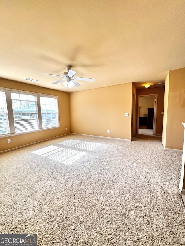 carpeted empty room featuring ceiling fan