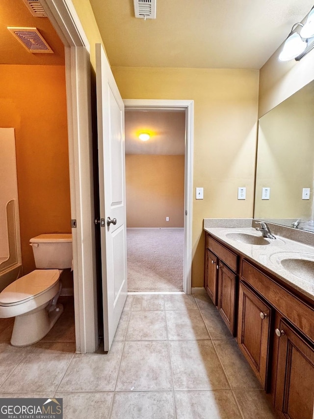 bathroom featuring vanity, tile patterned floors, and toilet