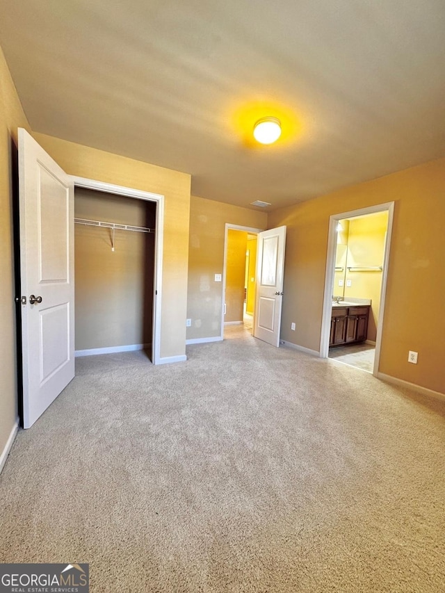 unfurnished bedroom with connected bathroom, carpet floors, and a closet